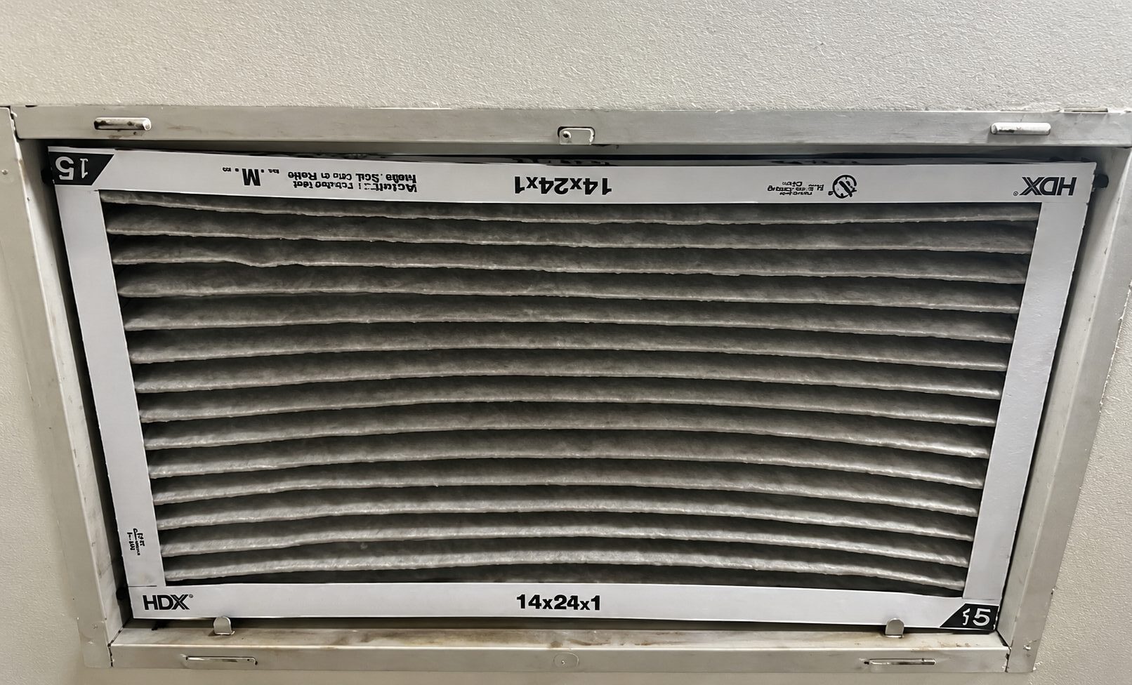 Photo showing heavily loaded/dirty filter bowing inward with excessive static pressure, causing the AC to not keep up.